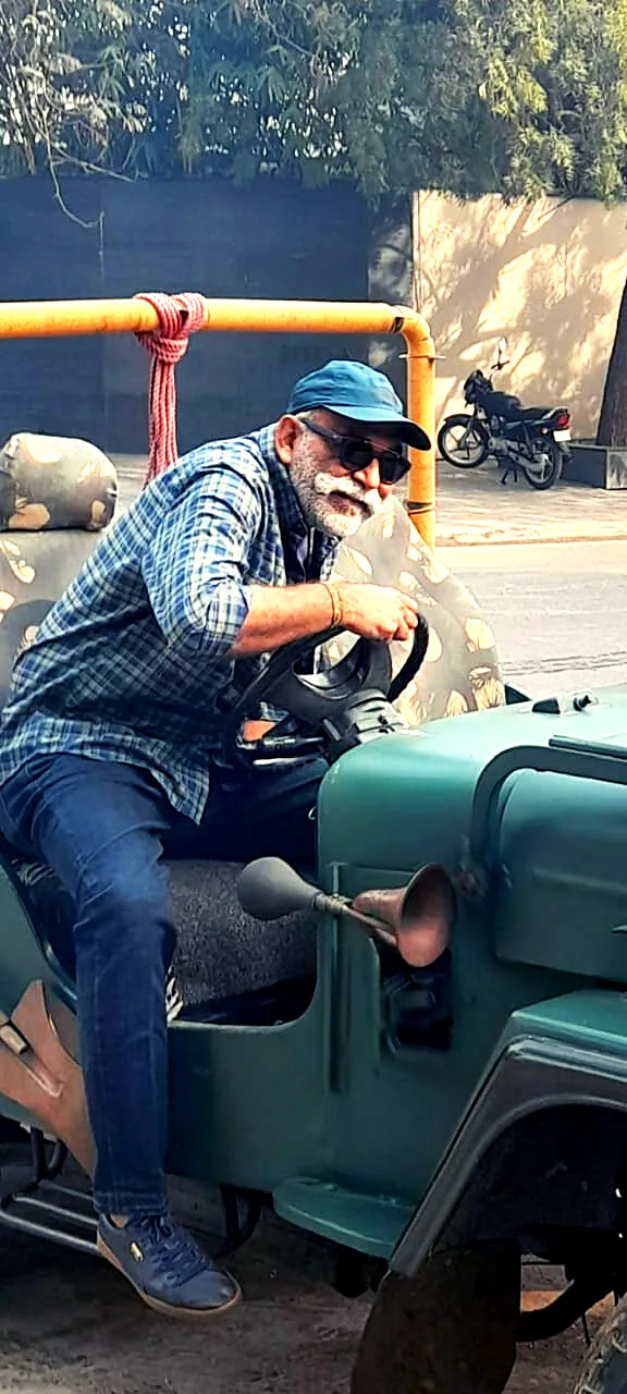 Mehul Vadodaria in a lifestyle portrait with a vintage car